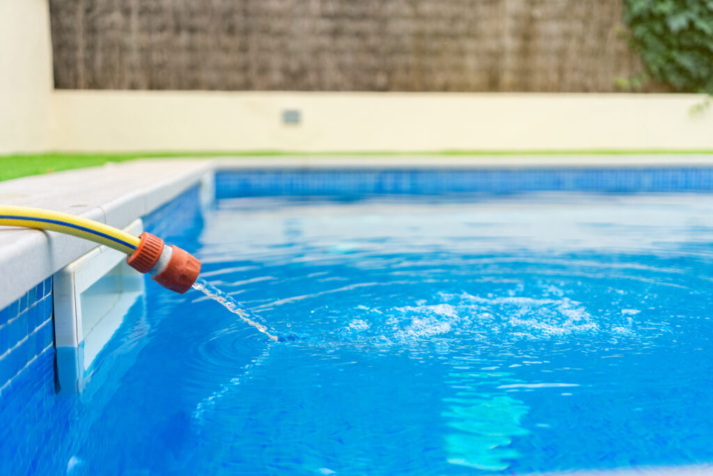 Filling up a Texas swimming pool with water.